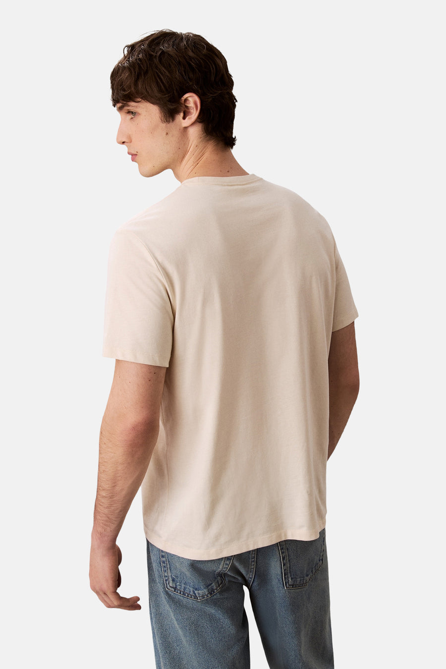 Ecru T-shirt met korte mouwen van Calvin Klein, gedragen met een blauwe jeans, achtergezicht.