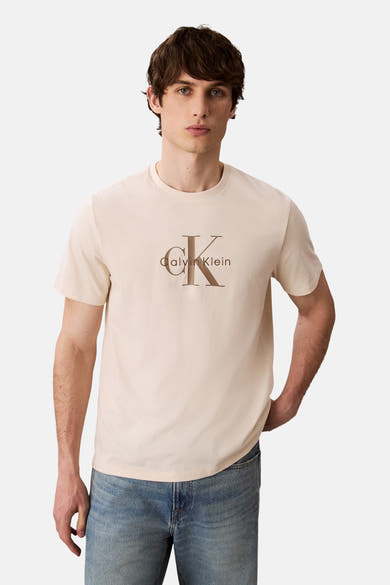 Ecru T-shirt met korte mouwen van Calvin Klein, met opdruk, gedragen met een blauwe jeans.