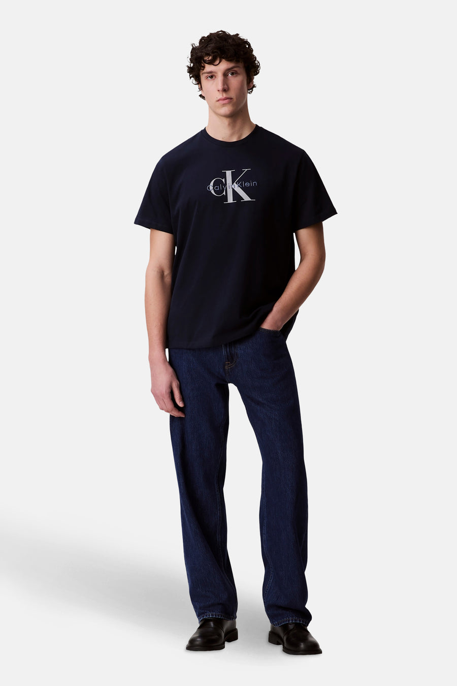 Donkerblauwe T-shirt met korte mouwen van Calvin Klein, gedragen met een spijkerbroek en zwarte schoenen.
