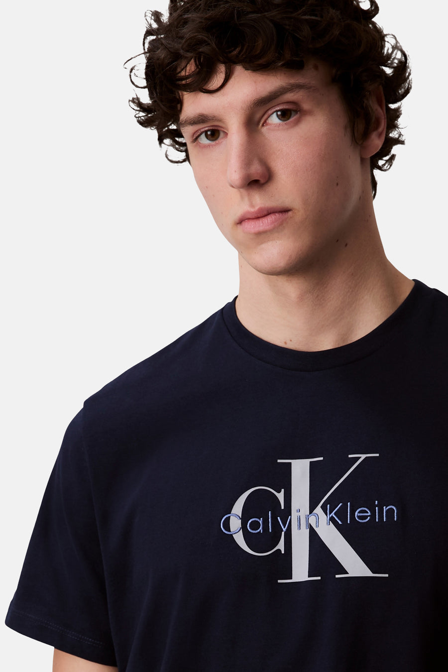 Donkerblauwe T-shirt met korte mouwen van Calvin Klein, met geborduurd CK-logo in wit en lichtblauw.