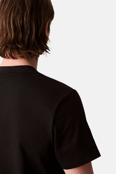 T-shirt noir à manches courtes de Calvin Klein, montrant le dos et les cheveux bruns du mannequin.