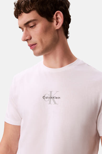 T-shirt à manches courtes blanc de Calvin Klein avec son logo emblématique, porté par un homme.
