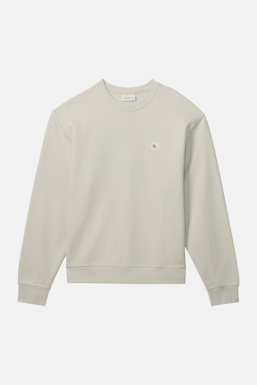Sweat-shirt beige en coton, de Calvin Klein, avec un logo discret sur la poitrine.
