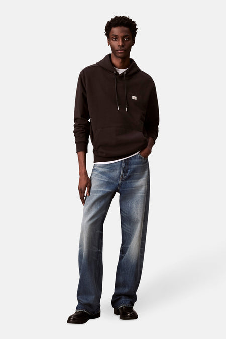 Zwarte Calvin Klein hoodie, gedragen met een wit T-shirt en een verbleekte spijkerbroek.