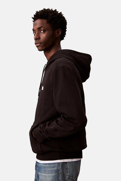 Sweat à capuche noir de Calvin Klein, porté avec un t-shirt blanc et un jean, en vue de côté.