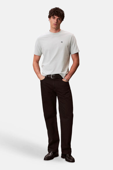Blauw T-shirt met korte mouwen van Calvin Klein, met een logo op de borst en gedragen met een zwarte broek en loafers.