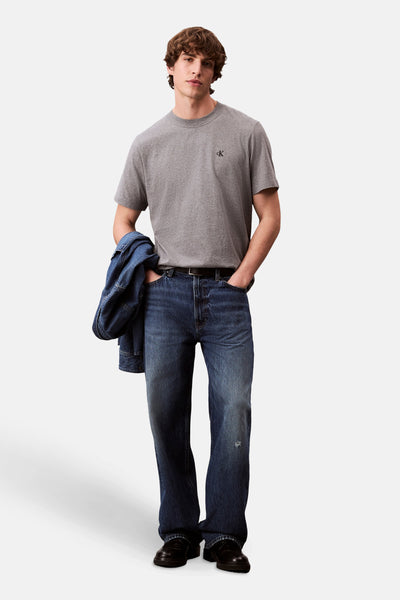 T-shirt à manches courtes gris de Calvin Klein, porté avec un jean brut et une veste en jean.