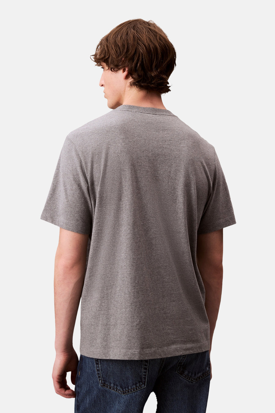 Grijs T-shirt met korte mouwen van Calvin Klein, van achteren gezien, gedragen met een donkerblauwe jeans.