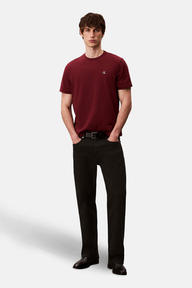 Bordeaux T-shirt met korte mouwen van Calvin Klein, gedragen met een zwarte jeans en een leren riem.