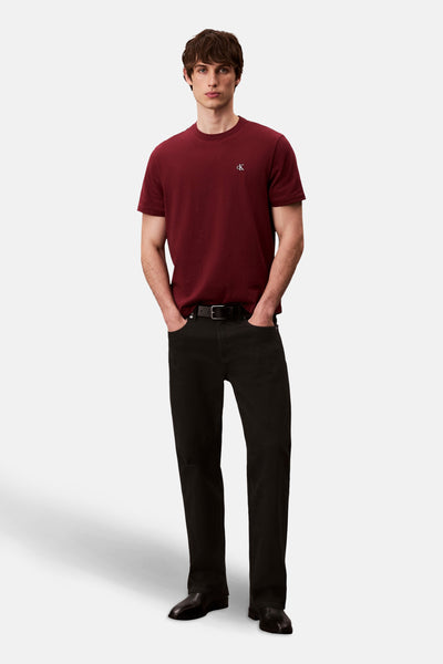 Bordeaux T-shirt met korte mouwen van Calvin Klein, gedragen met een zwarte jeans en een leren riem.
