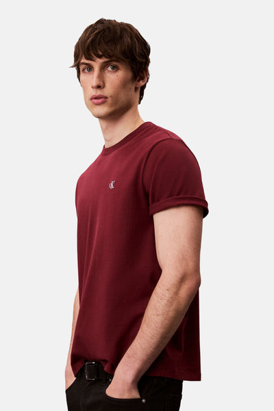 T-shirt bordeaux à manches courtes de Calvin Klein, porté avec un pantalon noir et une ceinture.
