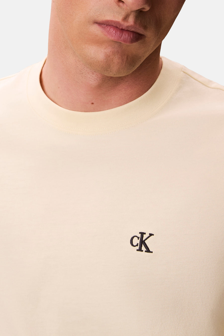 T-shirt jaune à manches courtes de Calvin Klein, avec logo brodé « cK » sur le devant.