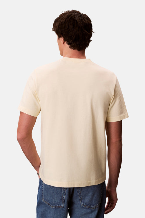 T-shirt à manches courtes jaune de Calvin Klein, porté avec un jean bleu, vue de dos.