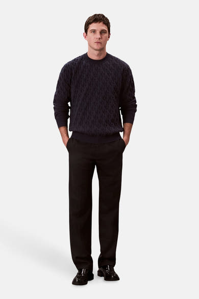 Sweat-shirt bleu de Calvin Klein, avec motif texturé, porté avec un pantalon noir et des chaussures noires.