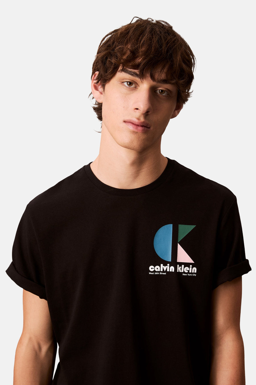 T-shirt à manches courtes noir de Calvin Klein, avec un logo géométrique sur la poitrine et des manches roulées.
