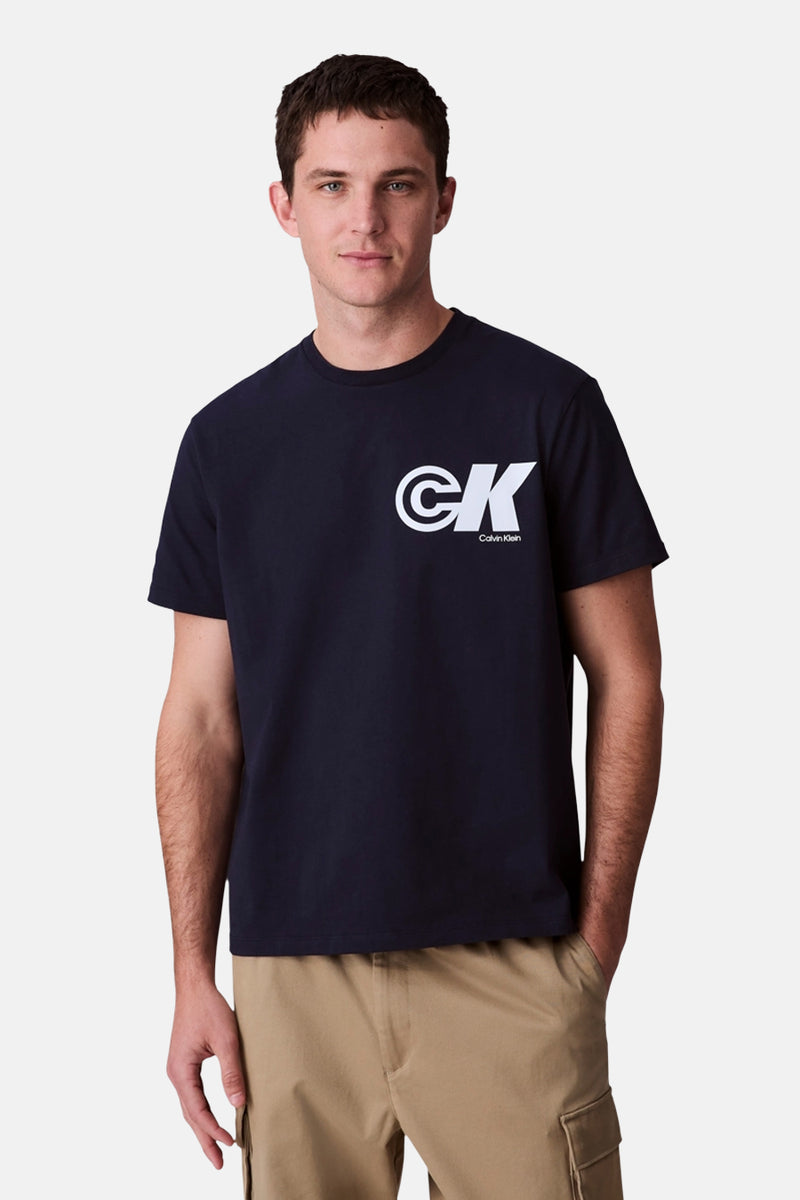 Blauw T-shirt met korte mouwen van Calvin Klein, met wit logo op de voorkant, gedragen met een beige cargobroek.
