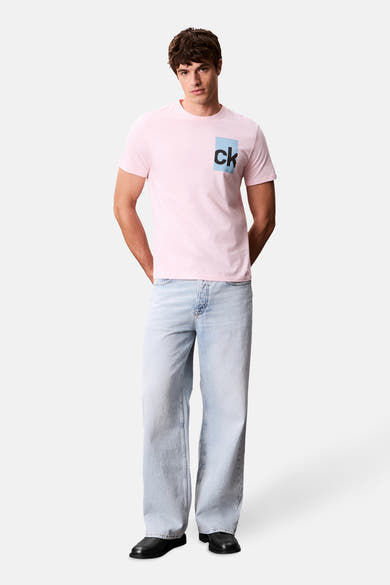T-shirt rose à manches courtes de Calvin Klein, avec logo carré sur le devant, porté avec un jean ample.