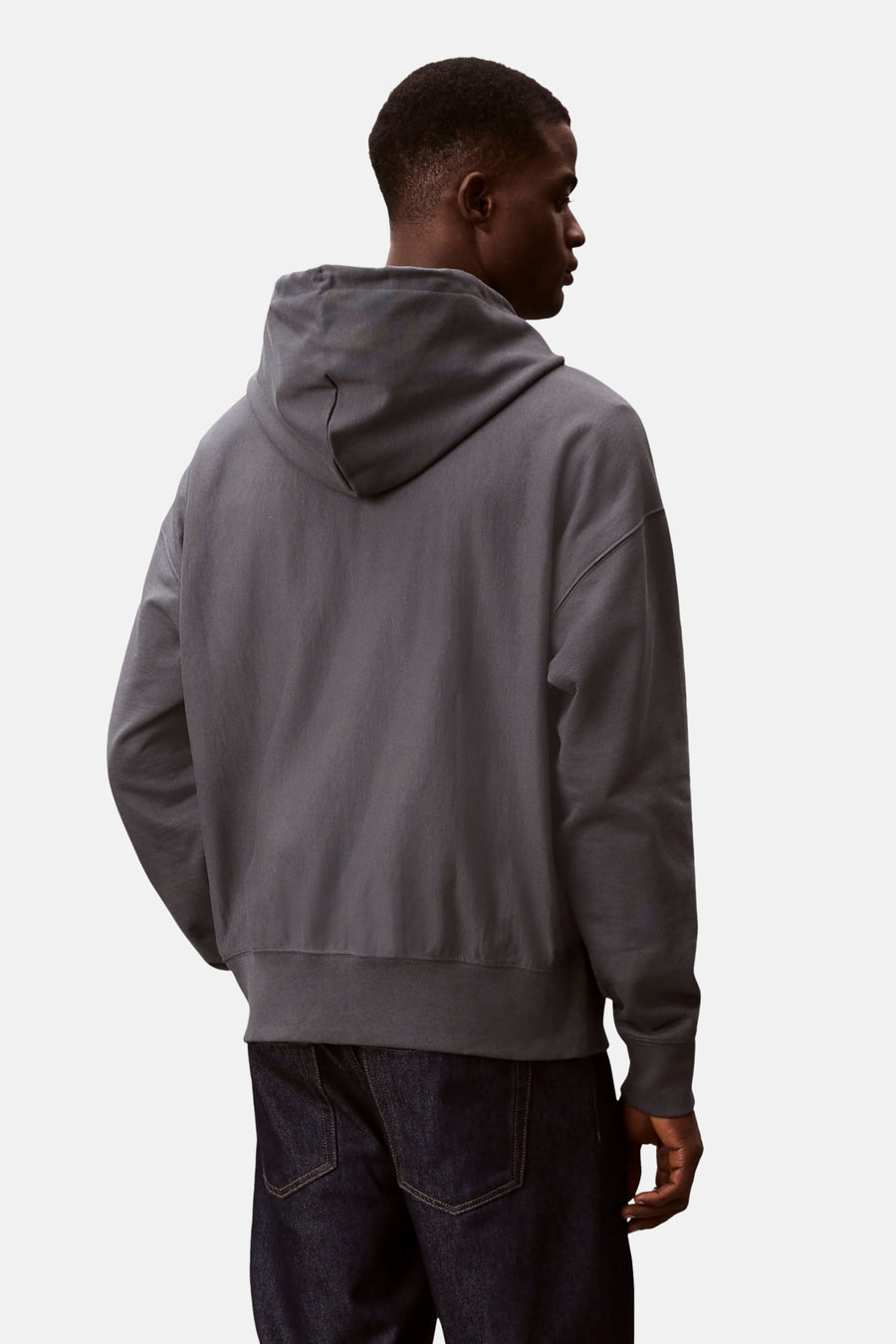 Blauwe Calvin Klein sweatvest met capuchon, gedragen met een donkere spijkerbroek, achtergezicht.