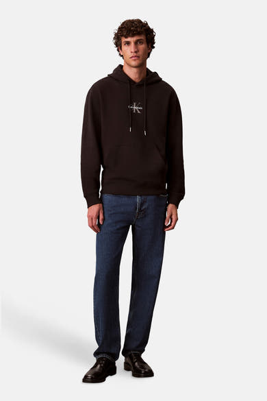 Zwarte Calvin Klein hoodie met logo op de voorkant, gedragen met een blauwe jeans en zwarte schoenen.