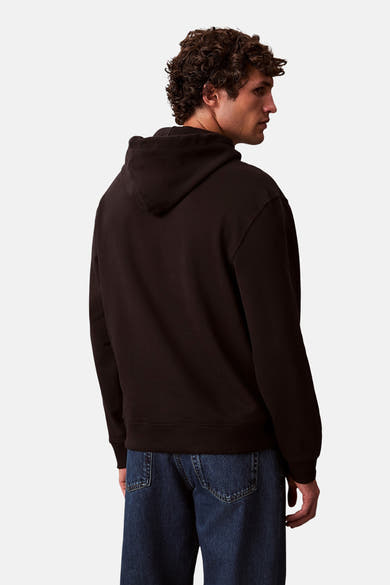 Zwarte Calvin Klein hoodie, met capuchon en gedragen met een blauwe jeans.
