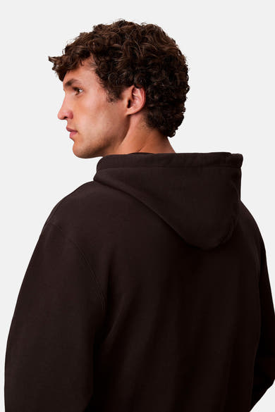 Zwarte Calvin Klein hoodie, met bruin krullend haar.