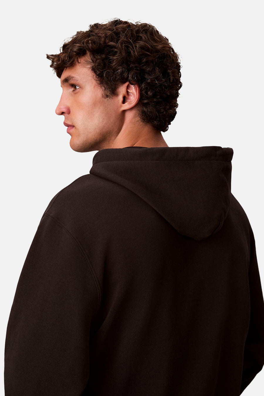Zwarte Calvin Klein hoodie, met bruin krullend haar.