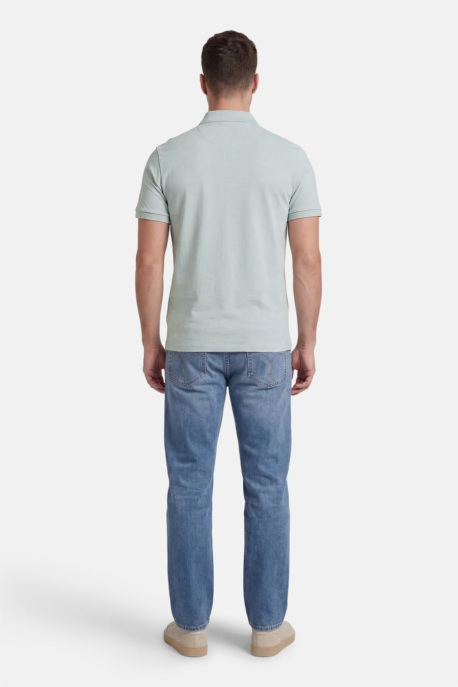 Polo à manches courtes bleu de Calvin Klein, porté avec un jean et des chaussures décontractées, vue arrière.
