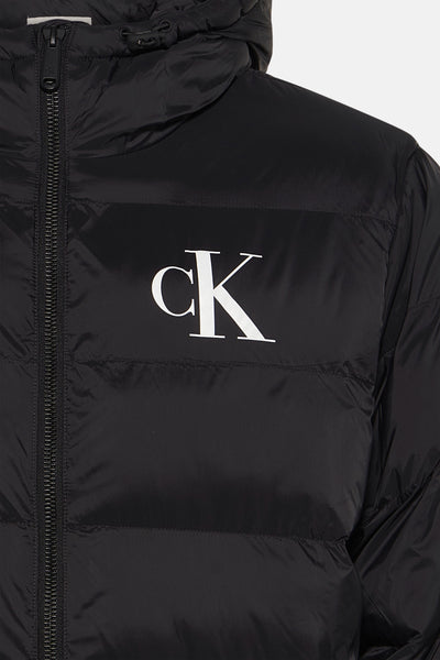 Zwarte regenjas van Calvin Klein met zichtbare ritssluiting en capuchon.