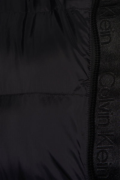 Veste de pluie noire de Calvin Klein, avec bande logo visible sur le côté.