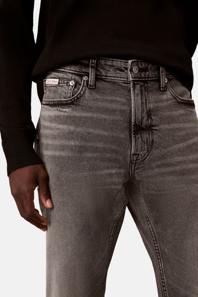 Calvin Klein slim jeans in middengrijs denim, met voorzakken en stikseldetail aan de voorkant.