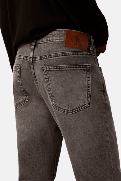 Slim jeans in middengrijs denim van Calvin Klein, met een bruin leren etiket aan de achterkant.