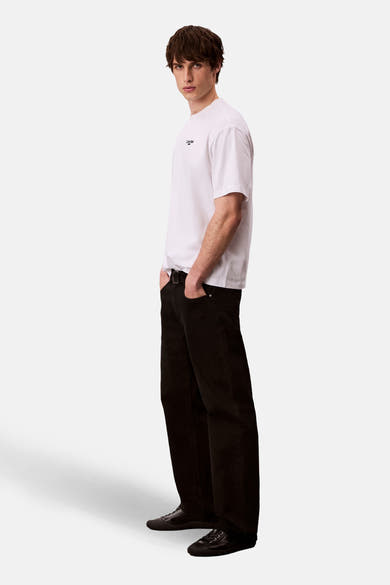 Wit T-shirt met korte mouwen van Calvin Klein, gedragen met een zwarte broek en zwarte schoenen.