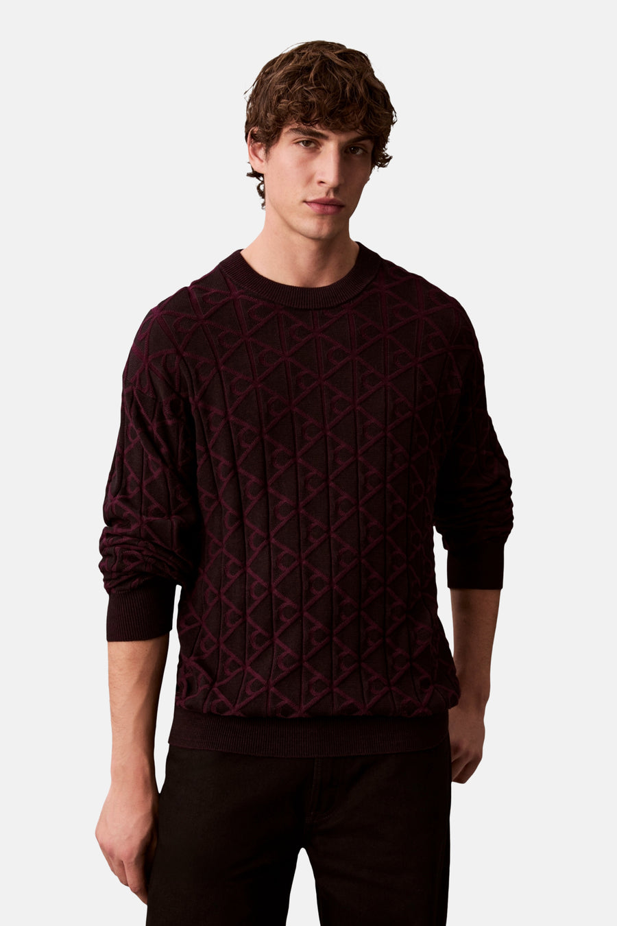 Zwart sweatshirt met ronde hals van Calvin Klein gedragen met een lange jas en een zwarte broek.