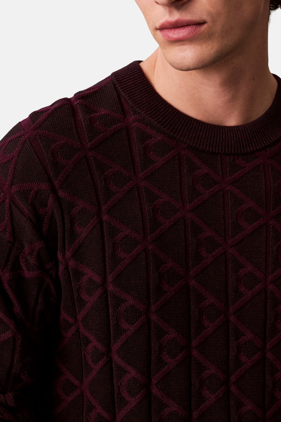 Zwarte rondehals sweatshirt van Calvin Klein, met een bordeauxrood ruitpatroon in jacquard.