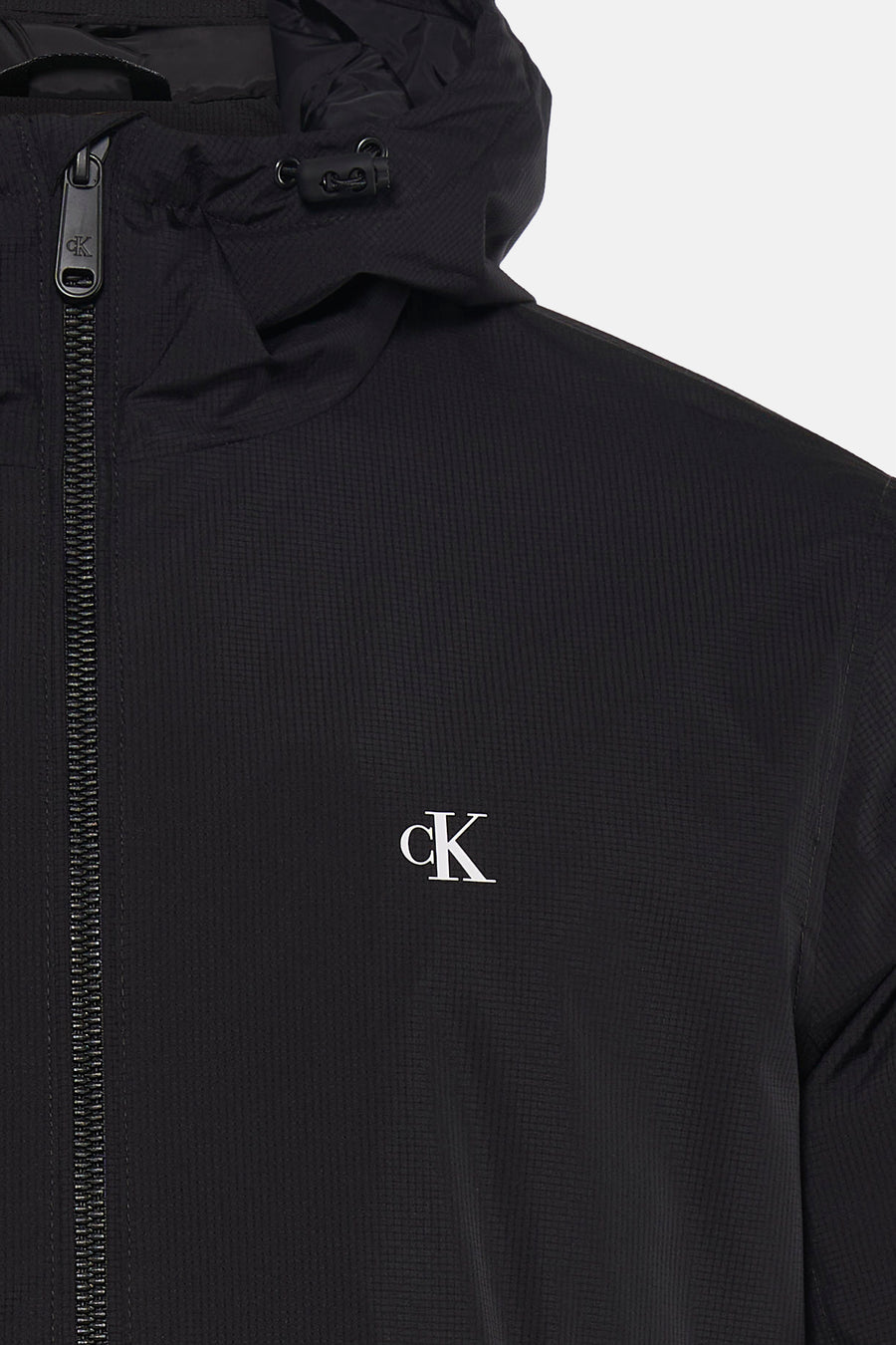 Zwarte regenjas van Calvin Klein met ritssluiting aan de voorkant en capuchon.