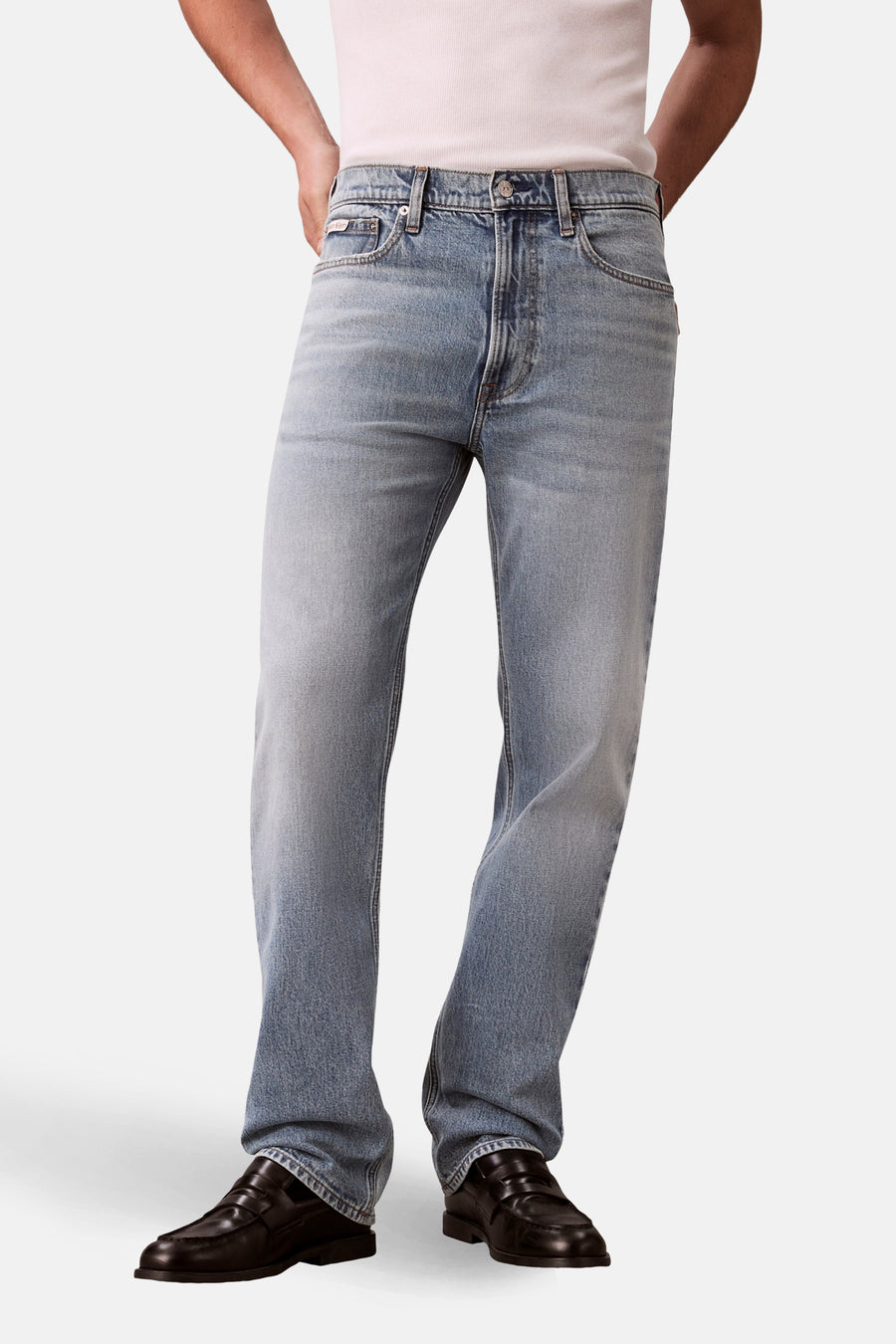 Rechte lichtblauwe spijkerbroek van Calvin Klein, gedragen met zwarte loafers.