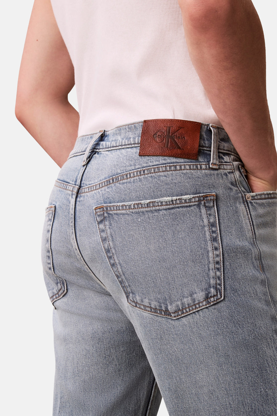 Rechte lichtblauwe spijkerbroek van Calvin Klein, met bruin leren patchdetail op de taille.