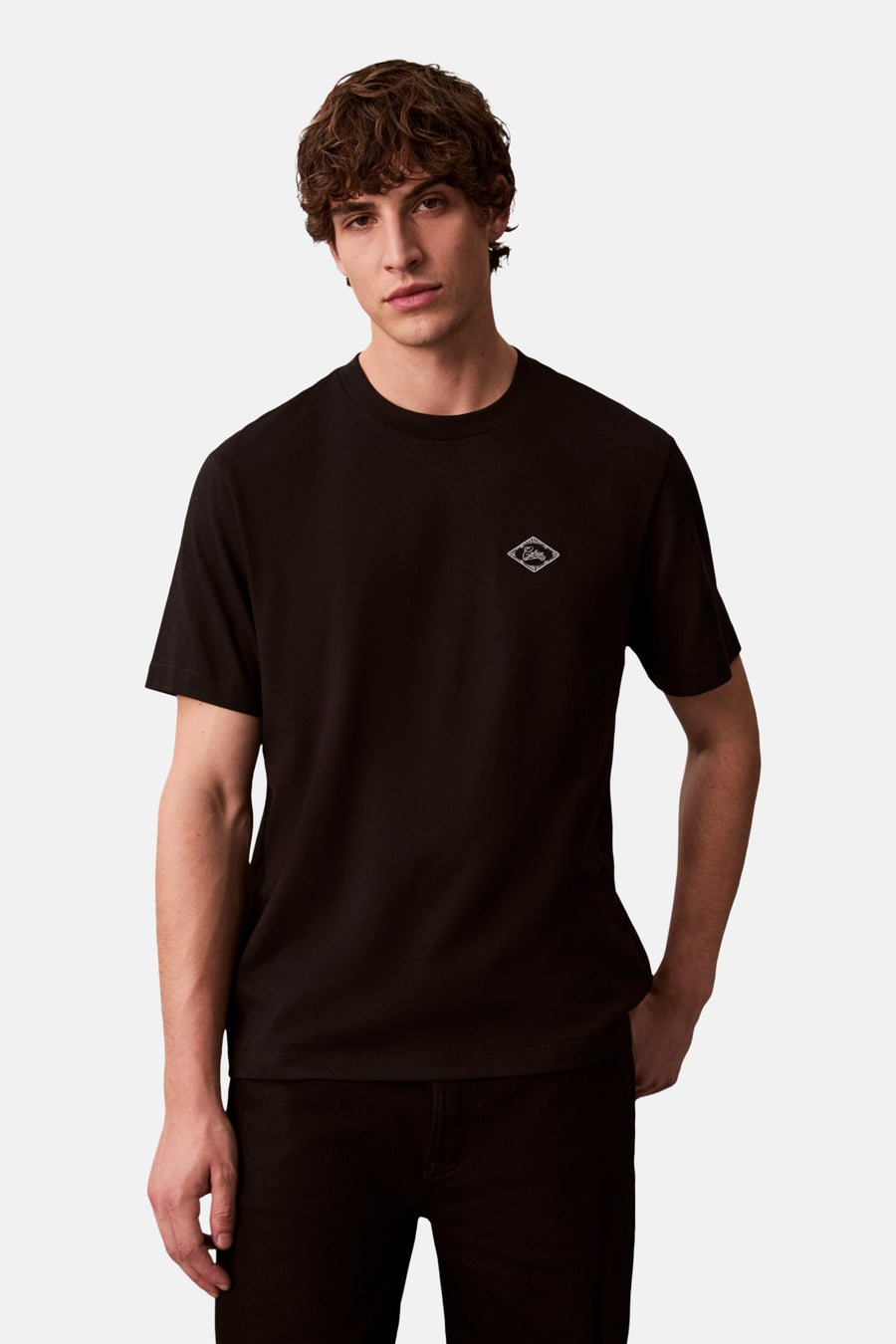 Zwart T-shirt met korte mouwen van Calvin Klein, gedragen met een bomberjack en een zwarte broek