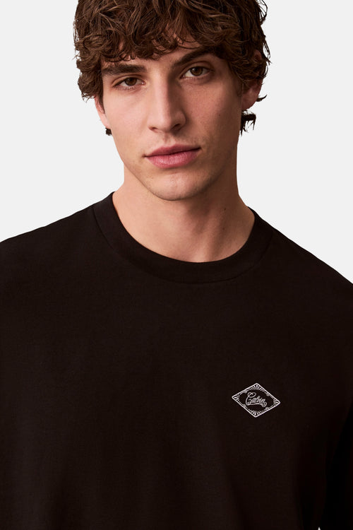 T-shirt noir à manches courtes de Calvin Klein, avec un petit logo brodé en losange sur le devant.
