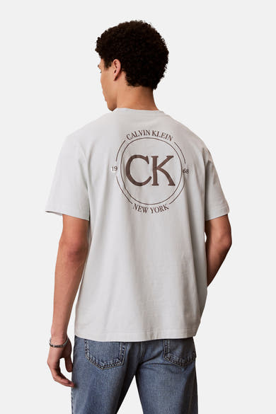 Blauw T-shirt met korte mouwen van Calvin Klein, met een grote cirkelvormige print op de rug.