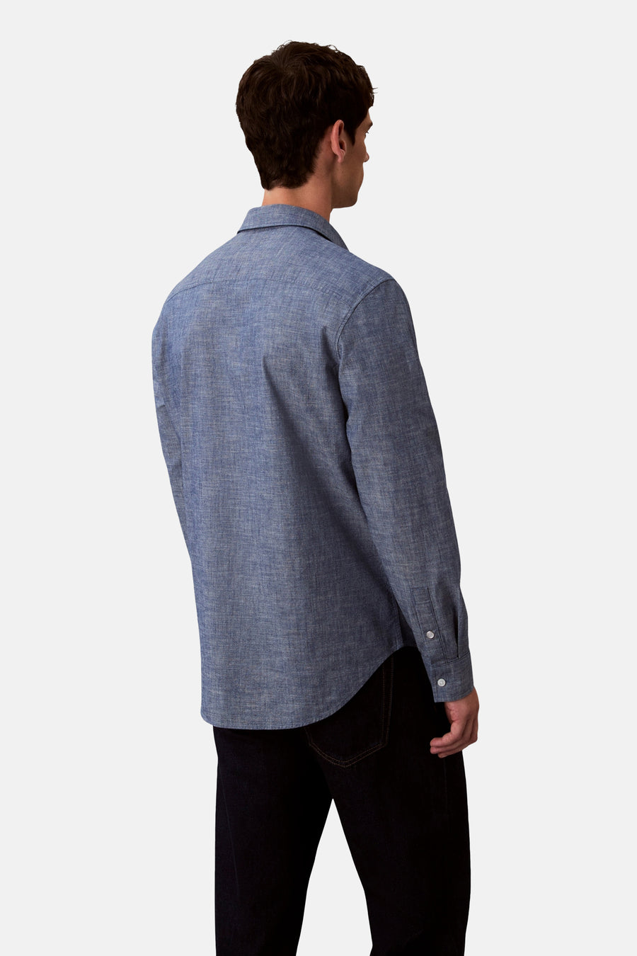 Chemise bleue à manches longues de Calvin Klein, vue de dos, portée avec un pantalon noir.