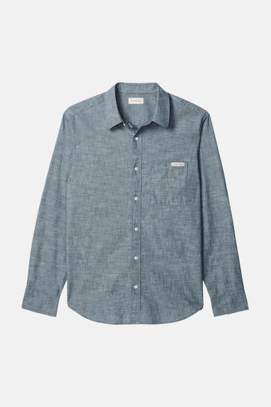 Chemise bleu à manches longues de Calvin Klein avec une poche poitrine boutonnée et une texture subtile.
