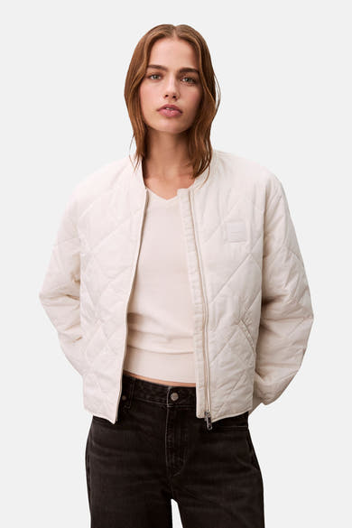 Ecru korte jas van Calvin Klein met ruitvormig doorgestikt patroon en zilverkleurige ritssluiting.