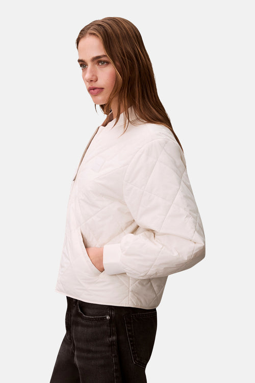 Veste courte écru de Calvin Klein, motif matelassé à losanges, avec poches latérales et fermeture éclair.
