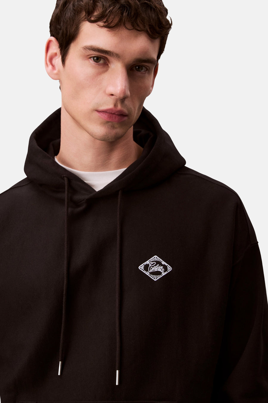 Sweat à capuche noir de Calvin Klein, avec cordon de serrage et logo brodé sur la poitrine.