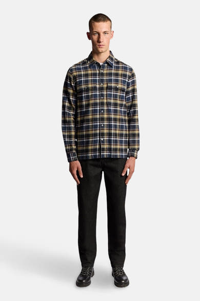 Chemise à manches longues multicolore de Lyle & Scott, à carreaux, portée avec un pantalon sombre et des chaussures lacées.