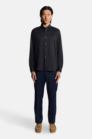Blauw overhemd met lange mouwen van LYLE & SCOTT, met een subtiel patroon, gedragen met een marineblauwe broek en bruine schoenen.
