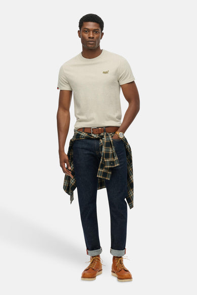 Grijs T-shirt met korte mouwen van SUPERDRY, gedragen met een geknoopte geruite blouse en een spijkerbroek.