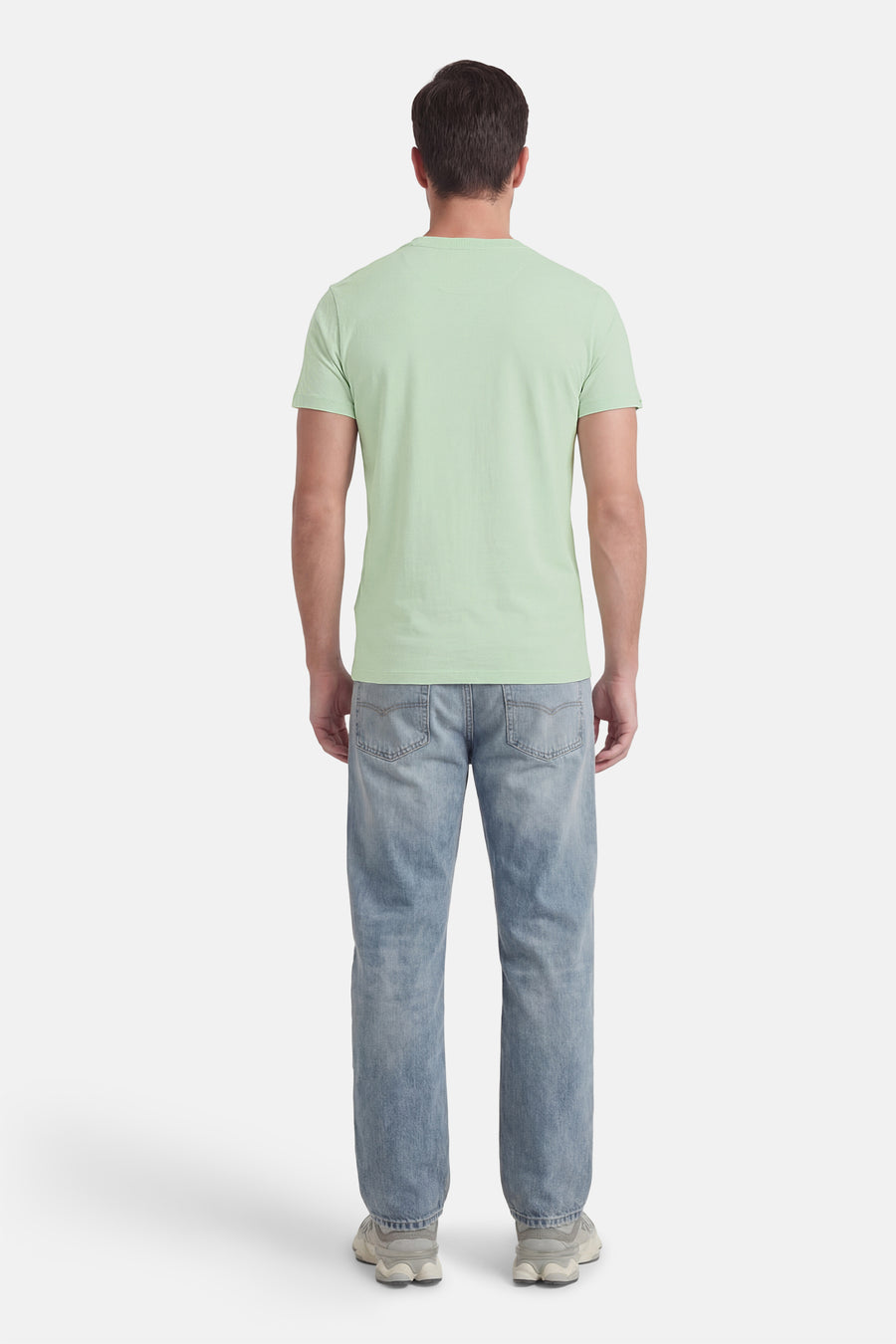 T-shirt à manches courtes vert de SUPERDRY, porté avec un jean bleu et des chaussures de sport grises, vue de dos.