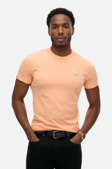 Oranje T-shirt met korte mouwen van SUPERDRY, gedragen met een zwarte jeans en een gespriem.